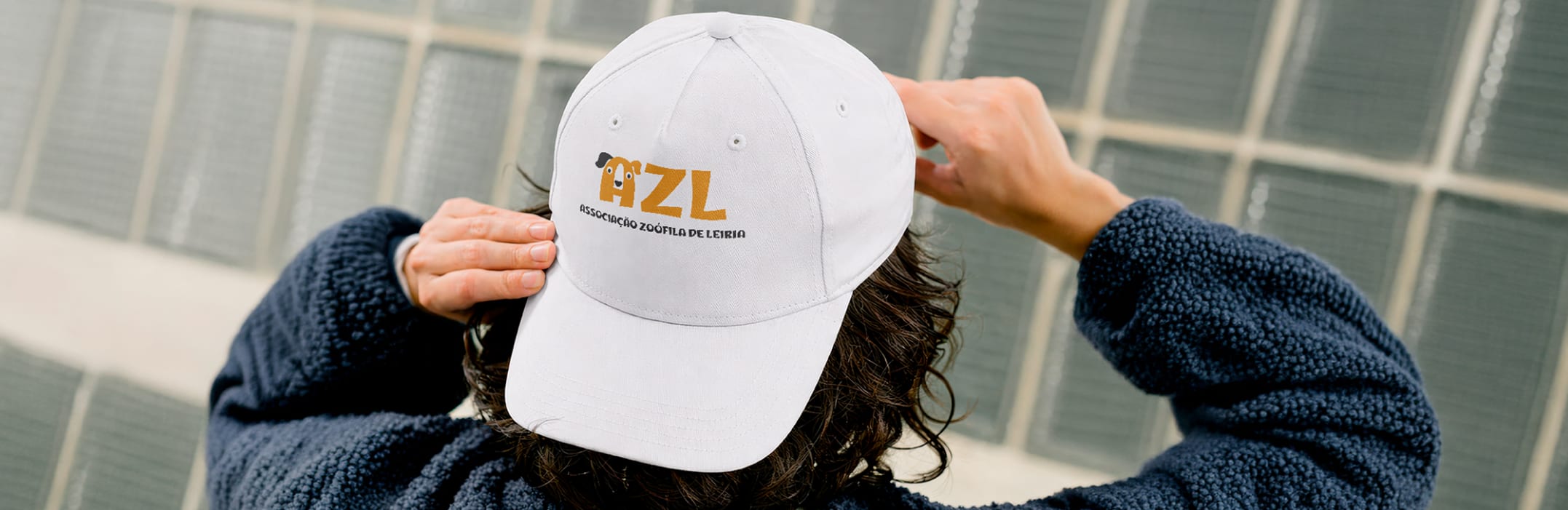 Person pulling on a white AZL cap